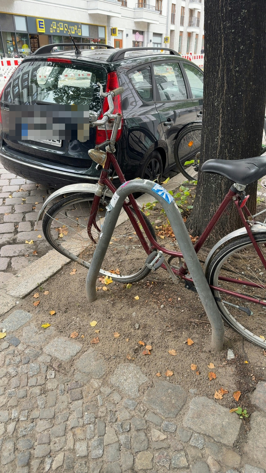 Ein beschädigtes, nicht fahrbereites Fahrrad ist an einem Baum festgeschlossen abgestellt, Marienburger Straße 14B, Pankow